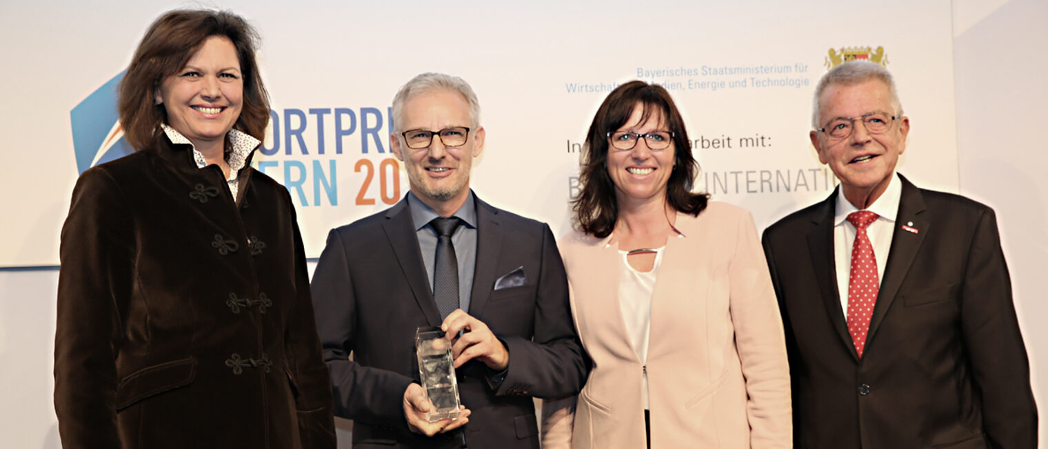 Die Gewinner des Eportpreises in der Kategorie Handwerk, Petra und Franz Fastner von Nowoflow, umrahmt von Wirtschaftsministerin Ilse Aigner und Laudator Heinrich Mosler.