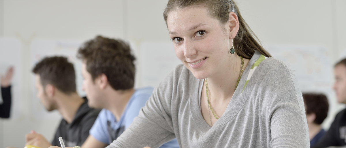 Unterricht im Meisterkurs Nahaufnahme, Kursteilnehmerin, sitzt, Tisch, lächelt, Meisterkurs, Unterricht, Bildungszentren_15582_argum