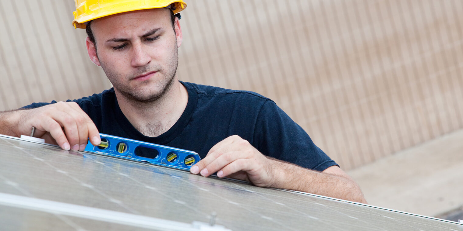 Konstruktion, Arbeiter, gelber Helm, Helm, Wasserwaage, Solarzellen, Solar Panels, Energie, erneuerbare Engerien, Elektrik, construction, worker, solar, panel, power, energy, electricity, electrician, building, efficiency, ladder, climbing, person, man, male, safety, hardhat, helmet, protective, roof, brick, blue collar, installation, installing, working, tools, equipment, outdoors, apprentice, journeyman, photovoltaic, cells, green, renewable, upgrade, repair, fix, maintenance, job, occupation, industrial, commercial, tradesman, level, adult, employment, environment