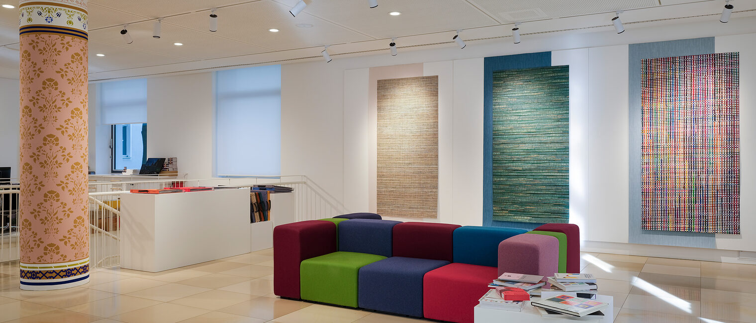 Blick in die Galerie Handwerk mit bunten Wandtapeten und Sofaelementen.