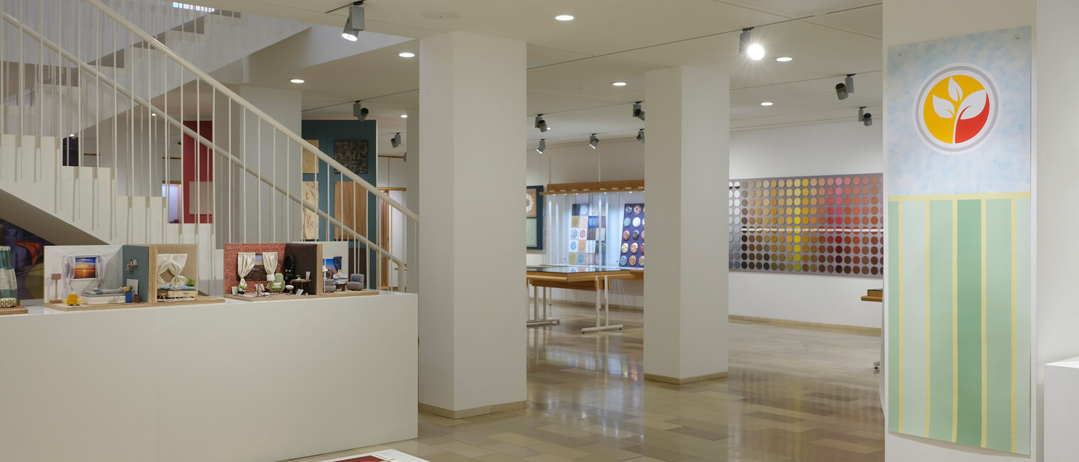 Ausstellungsraum mit bunten Wanddeko-Mustern, Farbmustern, kleinen Wohnraum-Modellen