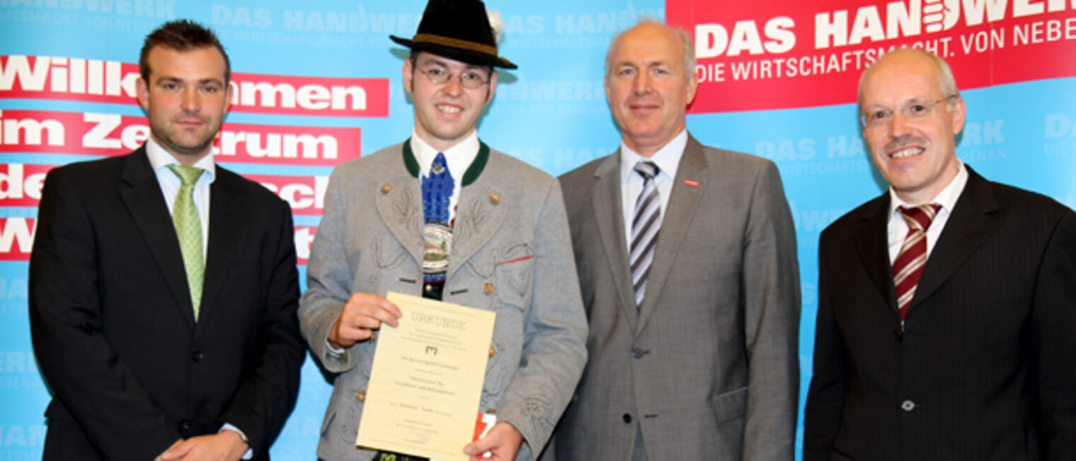 Zu sehen sind (v.li.n.re.): Stadtrat Georg Schlagbauer, Installateur und Heizungsbauermeister Sebastian Fuchs (Notenbester), Handwerkskammervizepräsident Franz Xaver Peteranderl und Schulleiter Georg Junior